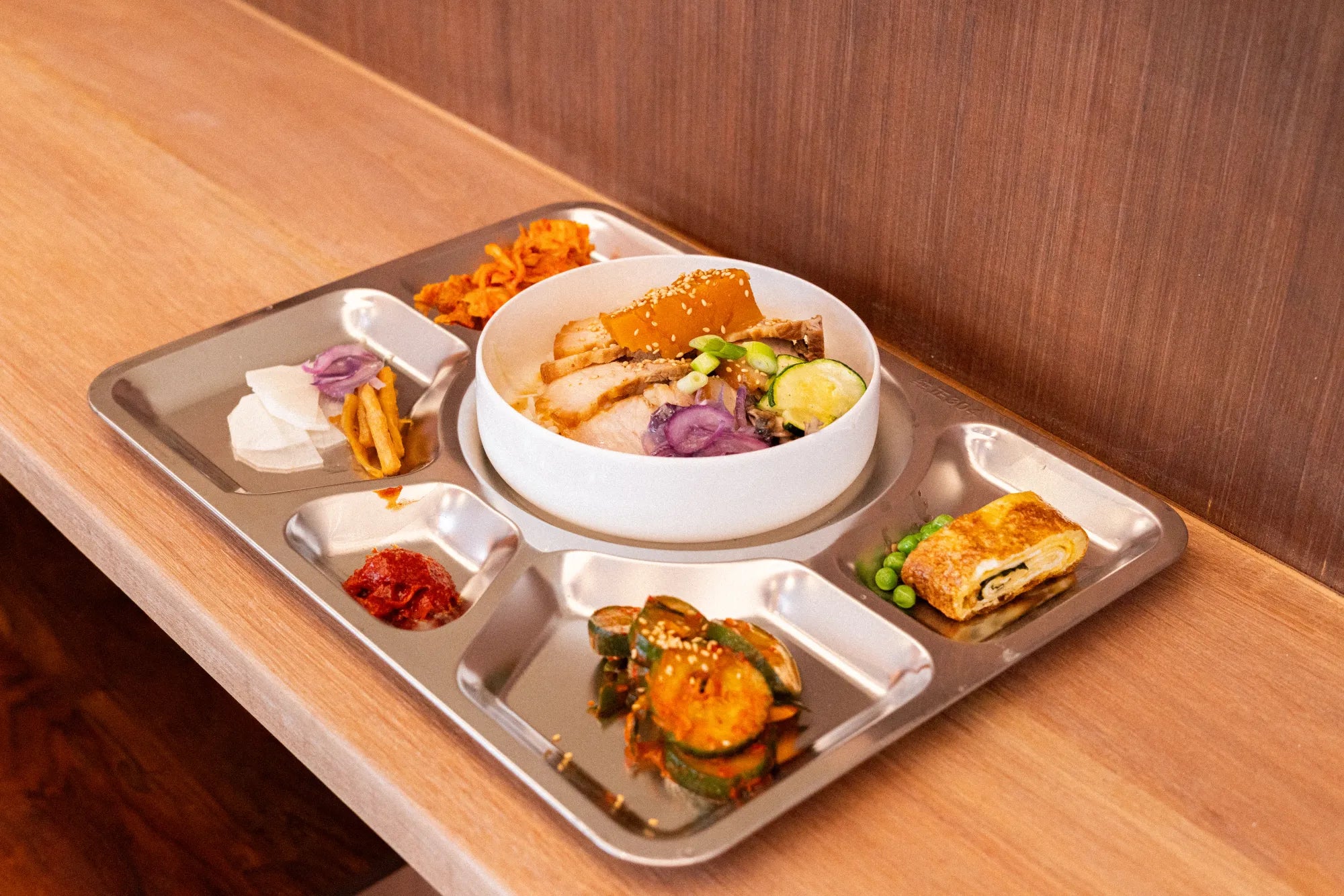 Tray of assorted Korean dishes on a wooden table